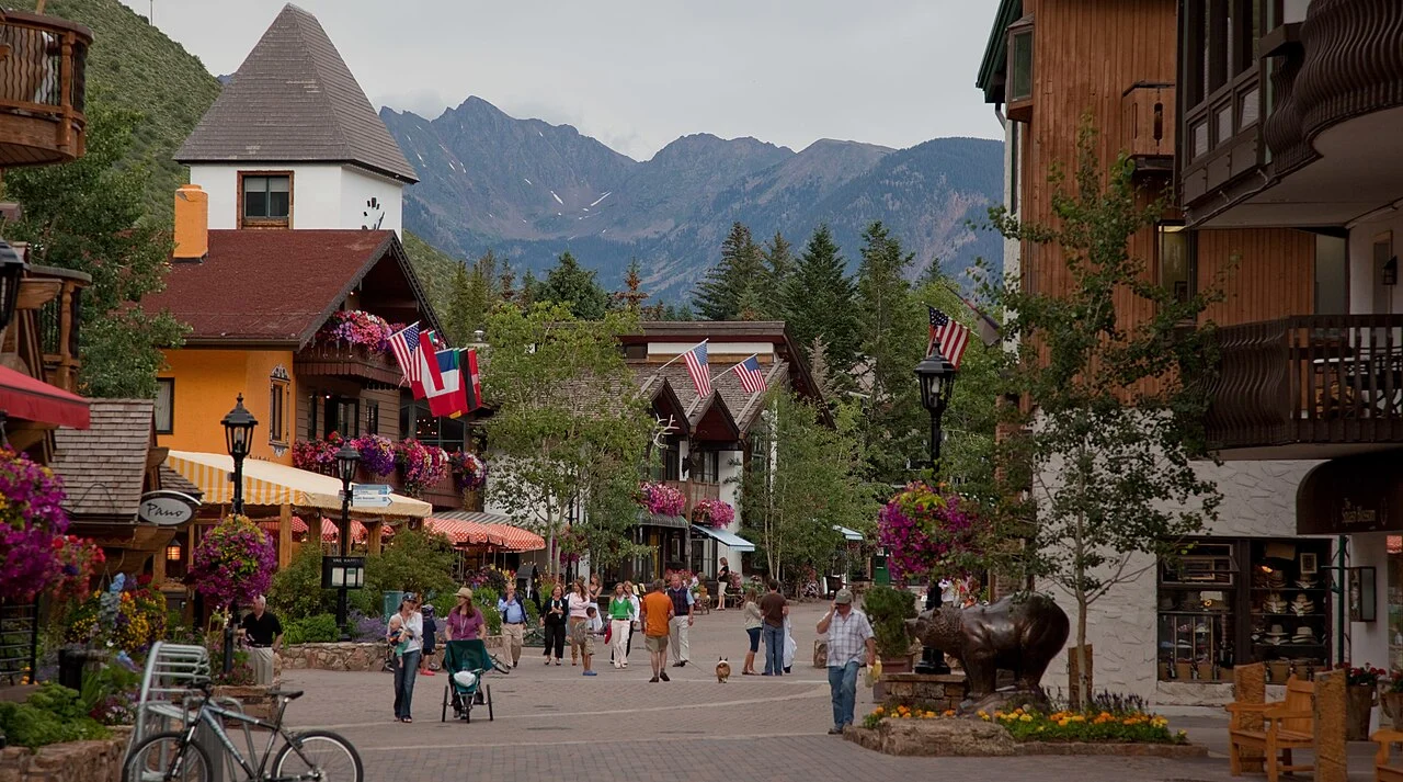 Vail village buildings along Gore Creek Drive with the Gore Range in the background.