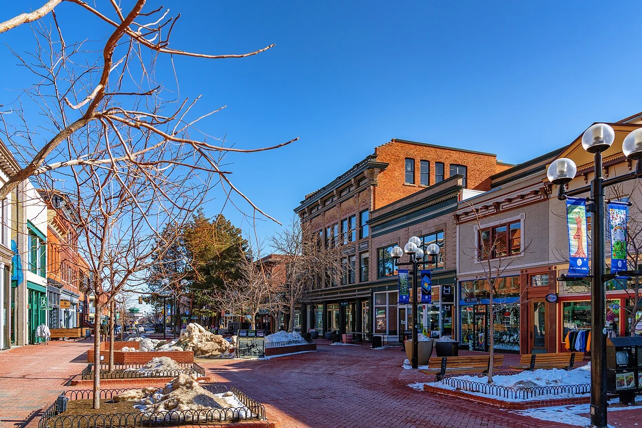 Brick storefronts and leafless trees along Pearl Street in downtown Boulder, Colorado.