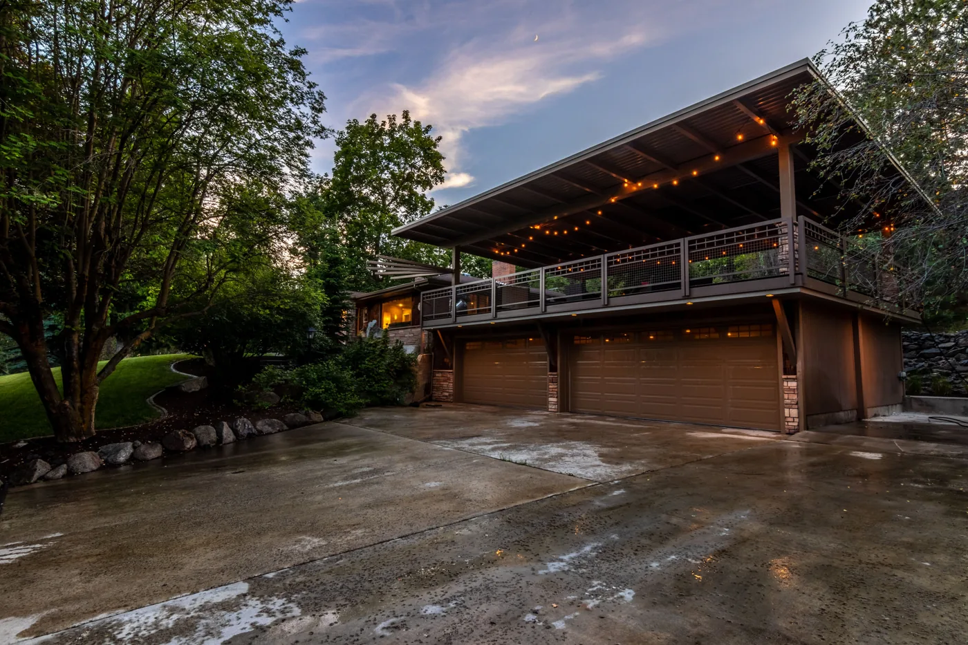 spacious two-story home at twilight with a balcony and landscaped yard