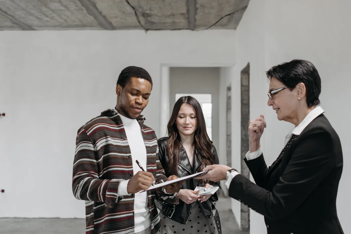 Homebuyers and an advisor reviewing plans inside a home under construction.