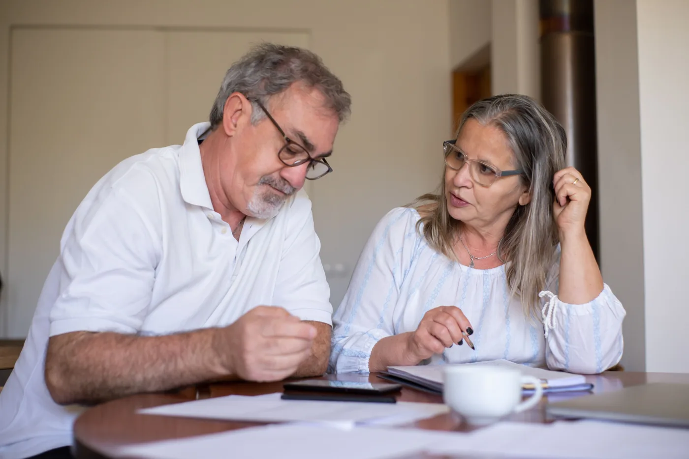 An older couple reviewing paperwork with an advisor.