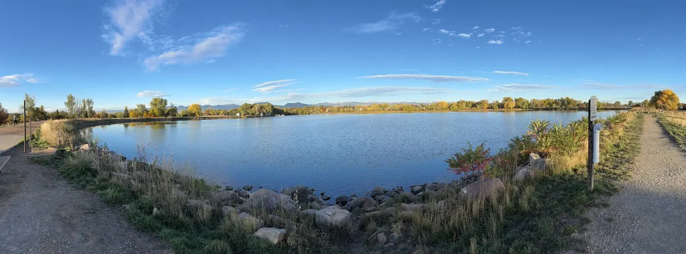 Waneka Lake, autumn trees and Front Range mountains in Lafayette, Colorado