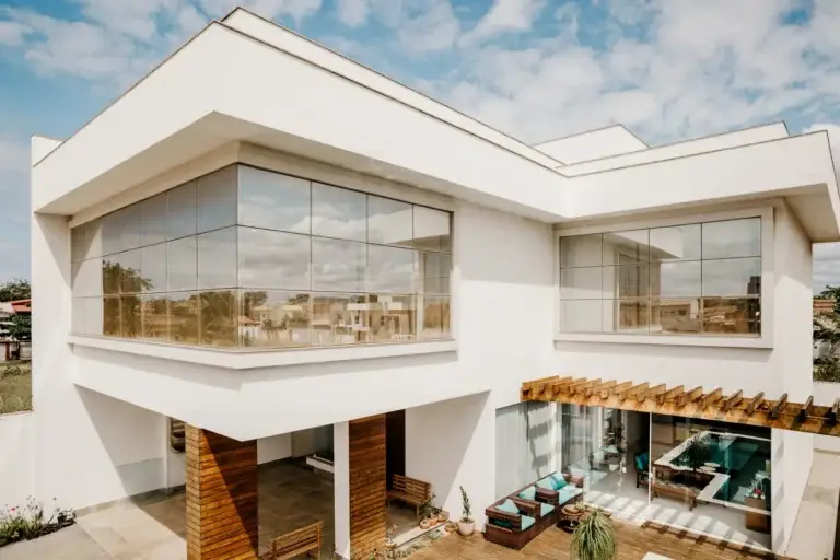 White contemporary home with broad windows and a landscaped front yard